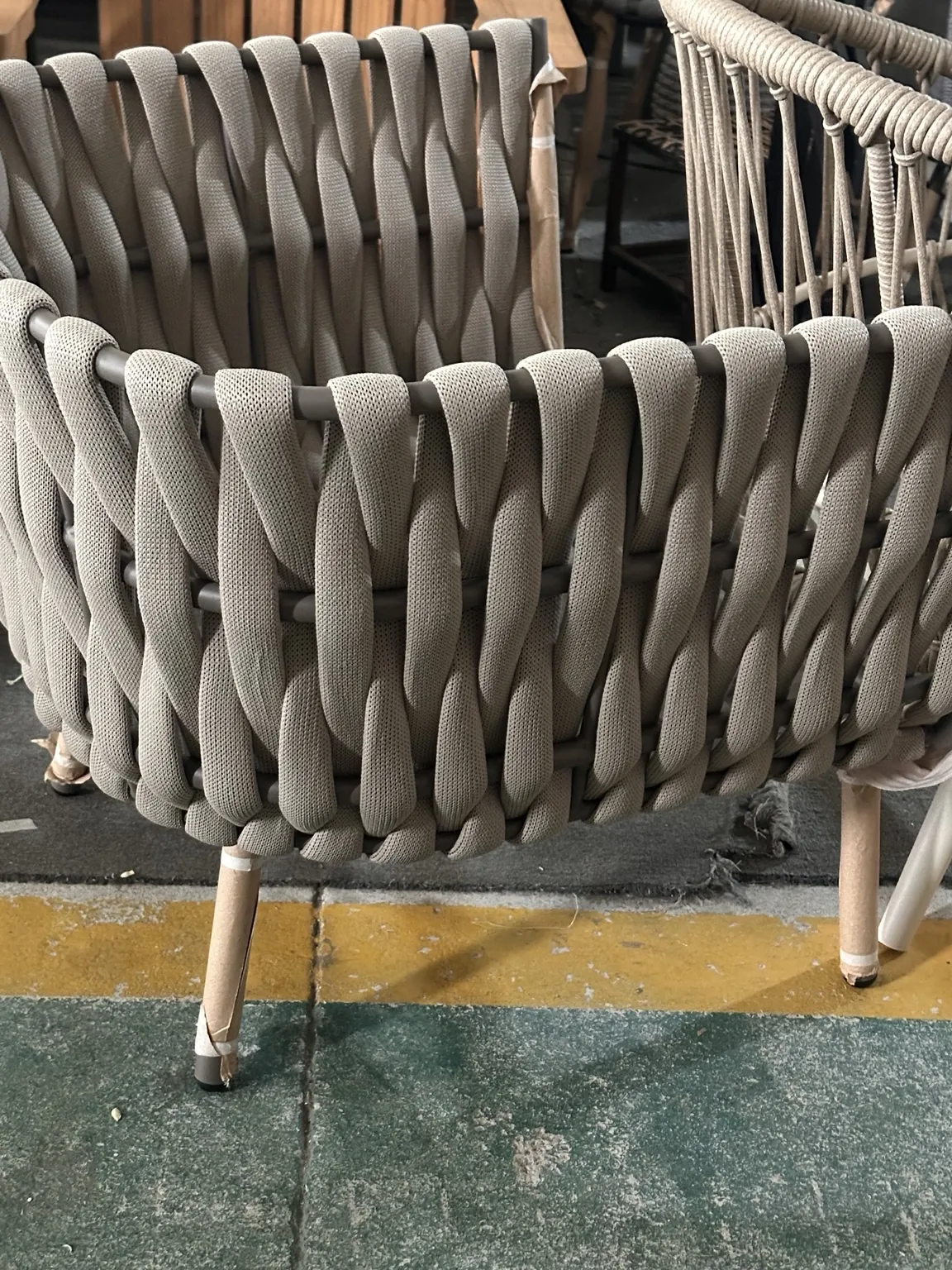 Close-up of a hand-woven rope seat under construction in a workshop