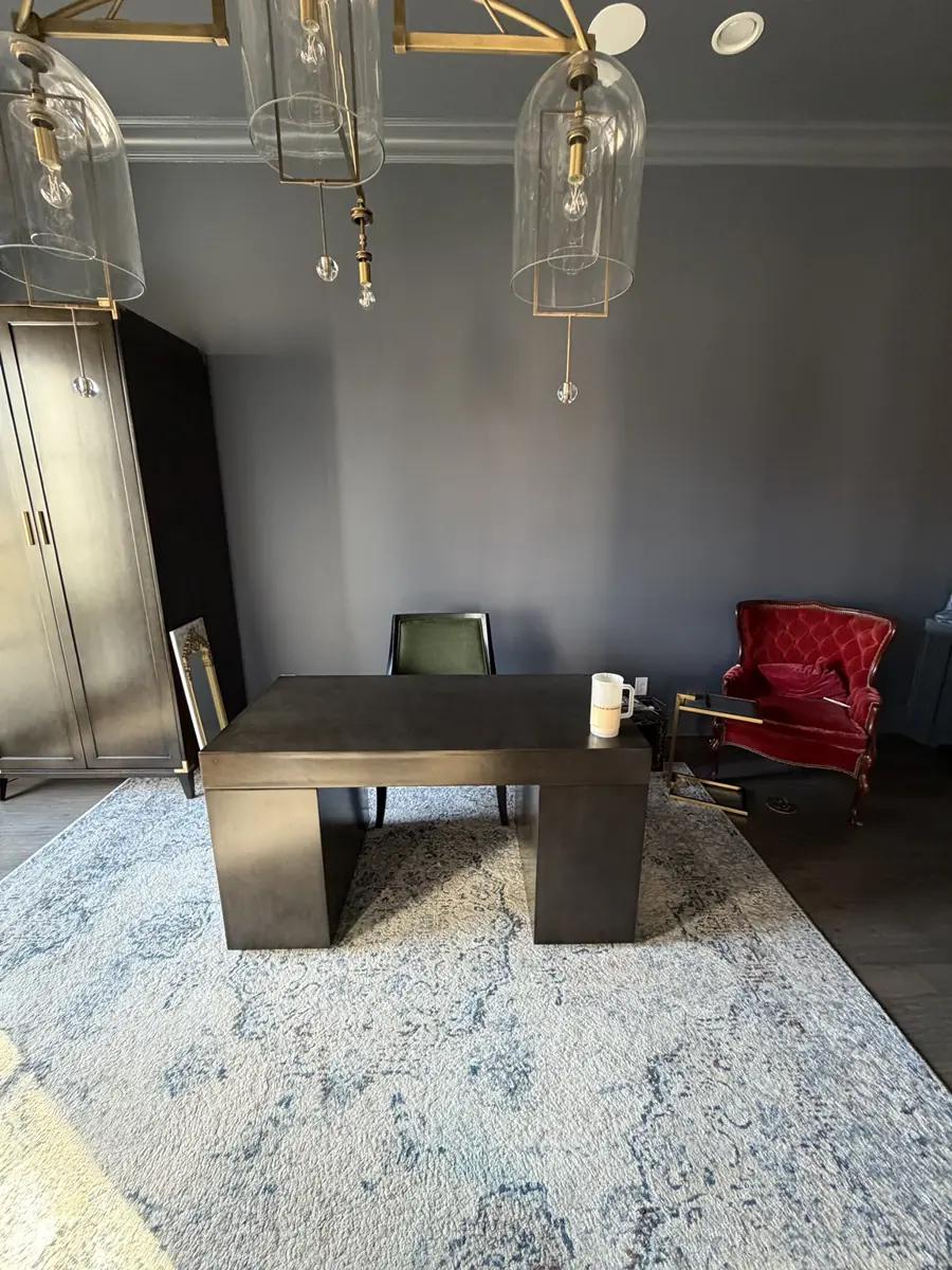 Dark office with sculptural chandelier and stone-top desk